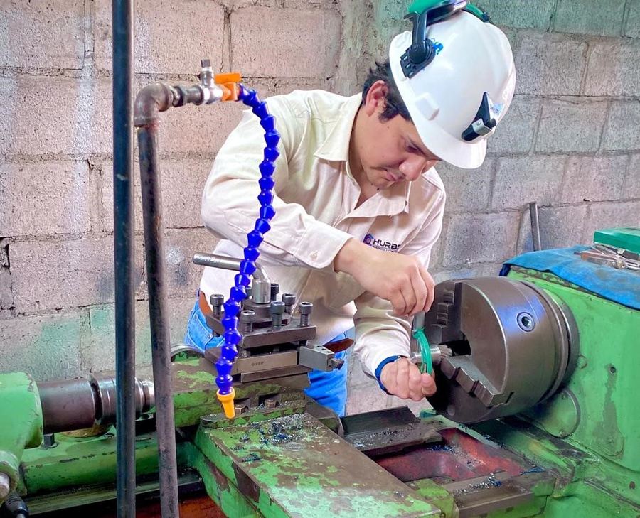 Técnico de Hurbec operando un torno paralelo en el taller de Cajamarca